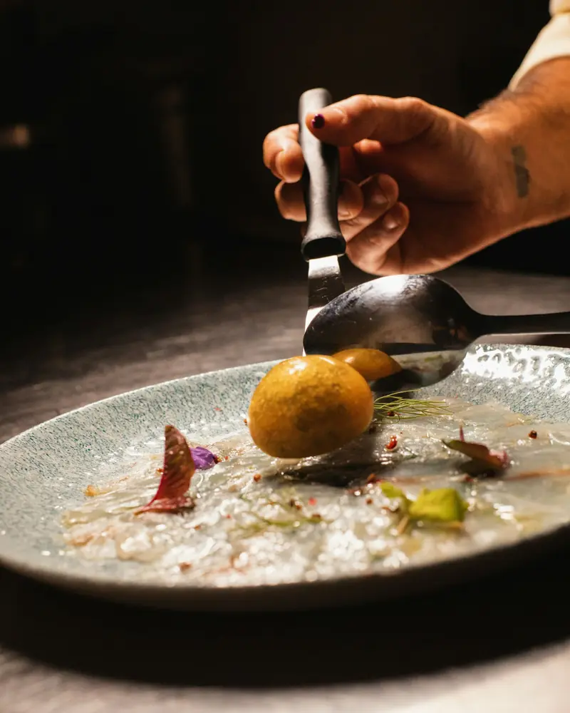 Mão ajustando com pinça um tempo do menu degustação