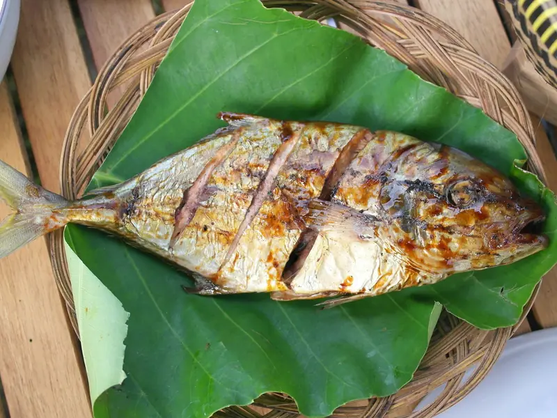 Peixe inteiro assado sobre folha de bananeira